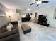 Relaxing living room featuring comfortable seating, neutral tile, and a view into the kitchen with bar seating at 5114 Hawkstone Dr, Sanford, FL 32771