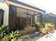 Screened-in patio includes modern seating, stylish tilework, potted plants and a view of the lush backyard at 5114 Hawkstone Dr, Sanford, FL 32771