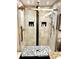 Elegant bathroom shower with black and white pebble-tiled floor and dual shower heads at 5114 Hawkstone Dr, Sanford, FL 32771