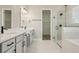 Bathroom featuring dual sinks, white cabinets, and a modern glass enclosed shower at 5254 Citrus Leaf Blvd, Winter Garden, FL 34787