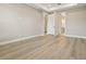 Bright bedroom featuring tray ceilings, light wood floors, and access to the ensuite bathroom at 5254 Citrus Leaf Blvd, Winter Garden, FL 34787