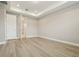 Bright bedroom featuring tray ceilings, light wood floors, and access to the ensuite bathroom at 5254 Citrus Leaf Blvd, Winter Garden, FL 34787