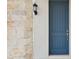 Stylish blue front door with stone accent wall and lantern, creating a welcoming entry at 5254 Citrus Leaf Blvd, Winter Garden, FL 34787