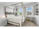 Bright bedroom with a four-poster bed, a built-in bookcase, and windows with natural light at 5393 Red Coral Cir, Mount Dora, FL 32757