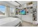 Spacious bedroom with a four-poster bed, built-in shelving, a workspace, and natural light at 5393 Red Coral Cir, Mount Dora, FL 32757