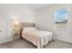 Bright bedroom featuring a plush upholstered headboard, neutral carpet, and natural light from a large window at 5393 Red Coral Cir, Mount Dora, FL 32757