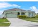 Well-manicured one-story home boasts lush landscaping, a two-car garage, and a welcoming driveway at 5393 Red Coral Cir, Mount Dora, FL 32757