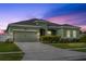 Charming one-story home with a well-maintained lawn and attached two-car garage, complemented by a colorful sunset backdrop at 5393 Red Coral Cir, Mount Dora, FL 32757