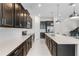 Open concept kitchen showcasing dark cabinetry, a large island with a sink, and modern appliances at 5393 Red Coral Cir, Mount Dora, FL 32757