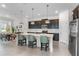 Modern kitchen featuring a large island with seating, stainless steel appliances, and dark cabinetry at 5393 Red Coral Cir, Mount Dora, FL 32757