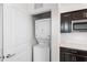 Space-saving laundry setup featuring a stacked washer and dryer, adjacent to dark cabinets and countertop at 5393 Red Coral Cir, Mount Dora, FL 32757
