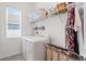 Functional laundry area with washer, dryer, storage baskets and shelving, perfect for efficient home management at 5393 Red Coral Cir, Mount Dora, FL 32757
