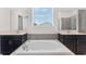 Elegant bathroom featuring a large soaking tub, dual sinks, and stylish mirrors at 5393 Red Coral Cir, Mount Dora, FL 32757
