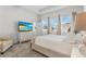 Bright main bedroom featuring a large window and a beach-themed TV display at 5393 Red Coral Cir, Mount Dora, FL 32757