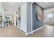 Hallway featuring wood floors, a large decorative wall hanging, and views of the dining and living areas at 6009 Tree Crossing Ln, St Cloud, FL 34771