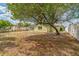 Backyard featuring a large shade tree and a privacy fence, with neighboring houses visible at 6042 Bolling Dr, Orlando, FL 32808