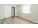 Bedroom featuring wood-look flooring, a closet and large window at 6042 Bolling Dr, Orlando, FL 32808