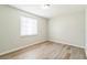 Bright bedroom featuring wood-look flooring and a window with blinds for natural light at 6042 Bolling Dr, Orlando, FL 32808