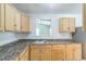 Bright kitchen features light wood cabinetry, laminate countertops, and an open view into an adjacent room at 6042 Bolling Dr, Orlando, FL 32808