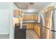 Well-lit eat-in kitchen featuring stainless steel refrigerator, black stove, updated countertops, and honey toned wood cabinets at 6042 Bolling Dr, Orlando, FL 32808