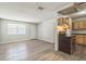 Bright living area with laminate floors and a front door, adjoins an eat-in kitchen with light-toned wooden cabinetry at 6042 Bolling Dr, Orlando, FL 32808