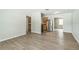 Spacious living room featuring modern wood-look flooring and neutral paint, leading to an open kitchen area at 6042 Bolling Dr, Orlando, FL 32808