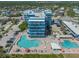 Aerial view of the condo complex featuring multiple pools, parking, and manicured landscaping at 611 S Atlantic Ave # 4212, New Smyrna Beach, FL 32169