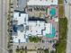 An overhead view of a blue and white apartment building with two pools, patios with lounge chairs, and parking spaces at 611 S Atlantic Ave # 4212, New Smyrna Beach, FL 32169