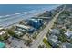 An aerial view of a blue apartment building with a pool and parking near the beach and houses at 611 S Atlantic Ave # 4212, New Smyrna Beach, FL 32169