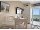 Bright dining area offers TV, beach decor, a white table and ocean view access at 611 S Atlantic Ave # 4212, New Smyrna Beach, FL 32169