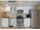 Compact kitchen featuring stainless steel appliances, granite counters, and white cabinetry at 611 S Atlantic Ave # 4212, New Smyrna Beach, FL 32169
