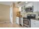 Efficient kitchen showcasing stainless steel appliances, granite counters, and white cabinetry at 611 S Atlantic Ave # 4212, New Smyrna Beach, FL 32169