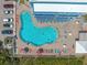 Aerial view of a pool surrounded by lounge chairs next to a building with balconies and parking at 611 S Atlantic Ave # 4212, New Smyrna Beach, FL 32169