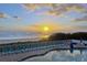 Inviting poolside view showcases sunset over ocean with lounge chairs for relaxing vacation at 611 S Atlantic Ave # 4212, New Smyrna Beach, FL 32169