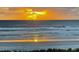 Beautiful sunset over the ocean with golden light reflecting on the waves and sandy beach at 611 S Atlantic Ave # 4212, New Smyrna Beach, FL 32169