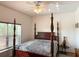 Bedroom with a canopy bed, ceiling fan, and natural light from the nearby window at 6730 Orlando Drive, Indian Lake Estates, FL 33855