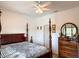 Comfortable bedroom with dark wood furnishings, neutral decor, and a ceiling fan at 6730 Orlando Drive, Indian Lake Estates, FL 33855