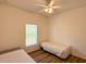 Bedroom featuring twin beds, wood-look flooring, and a ceiling fan at 6730 Orlando Drive, Indian Lake Estates, FL 33855