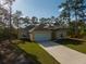 Charming single-story home featuring a well-manicured lawn and a long driveway at 6730 Orlando Drive, Indian Lake Estates, FL 33855