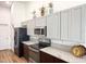 Modern kitchen with stainless steel appliances, granite countertops, and dark wood cabinets with light gray accents at 6730 Orlando Drive, Indian Lake Estates, FL 33855