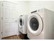 This laundry room features a stacked washer and dryer along with an entry door at 6730 Orlando Drive, Indian Lake Estates, FL 33855