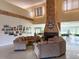 A well lit lobby with couches, tables, flowers, and paintings, along with a stone fireplace at 6730 Orlando Drive, Indian Lake Estates, FL 33855