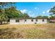 The exterior view of the home showcases the spacious backyard and the freshly painted white exterior at 6820 Ambassador Dr, Orlando, FL 32818