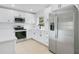 Updated kitchen with stainless steel appliances, white cabinets, and a quartz countertop at 6820 Ambassador Dr, Orlando, FL 32818
