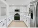 Updated kitchen with stainless steel appliances, white cabinets, and a quartz countertop at 6820 Ambassador Dr, Orlando, FL 32818