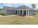A single-story home featuring modern architecture, a manicured lawn and a welcoming front porch at 72 Fairway Cir, Umatilla, FL 32784