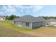Well-maintained home featuring a gray exterior with an attached garage and green lawn at 72 Fairway Cir, Umatilla, FL 32784