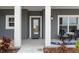 Inviting front entrance features a gray door, white pillars, and outdoor seating for relaxing at 72 Fairway Cir, Umatilla, FL 32784