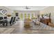 Sunlit living room features hardwood floors, a modern dining area, and plush seating at 72 Fairway Cir, Umatilla, FL 32784