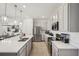 Modern kitchen with sleek stainless steel appliances, quartz countertops, and open design at 734 Longboat Dr, Davenport, FL 33896